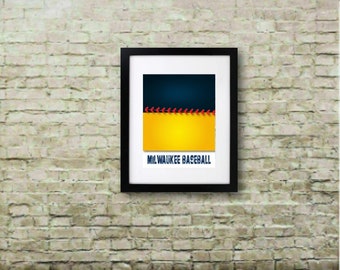 May include: A framed art print with a graphic design in navy blue and yellow, divided by a red stitch pattern. The text "MILWAUKEE BASEBALL" is printed in white. The black frame surrounds the artwork. The print is displayed on a brick wall.