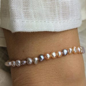 Armband tillverkat av lila sötvattenspärlor (klass 5A) och guldpläterade pärlor med ornament • sweety • minimalistiskt pärlarmband med soldesign