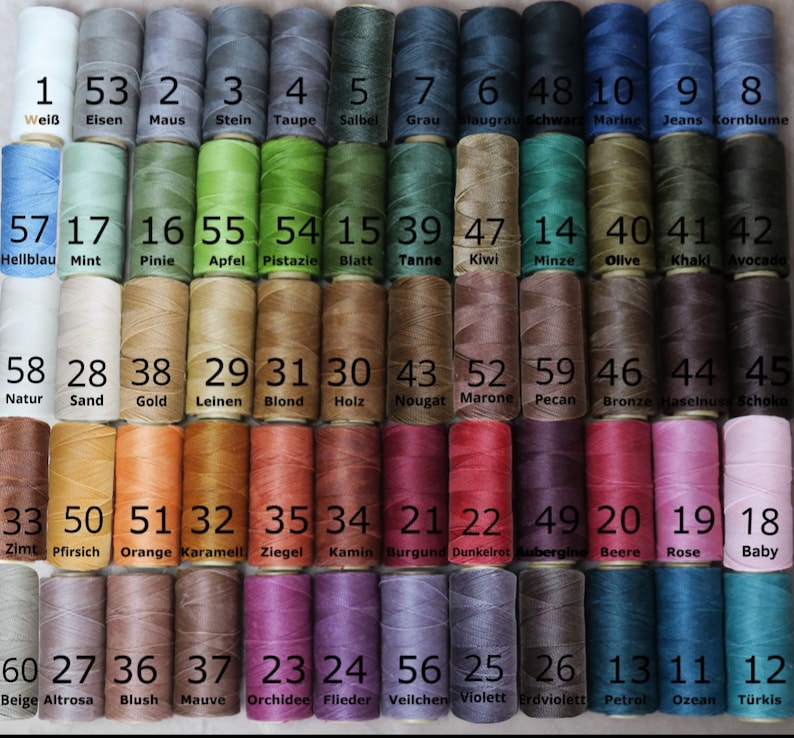 Puede incluir: Una tabla de 60 carretes de hilo, cada uno con un color y un n&uacute;mero diferentes. Los carretes est&aacute;n dispuestos en filas de 12, con los n&uacute;meros del 1 al 60 impresos debajo de cada carrete. Los colores incluyen blanco, gris, azul, verde, marr&oacute;n, naranja, rojo, rosa, morado y negro.