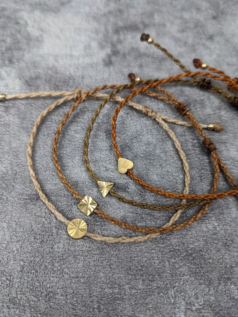 fußband mit goldenem herzchen oder sonne als freundschaftsband in naturtönen. verbindungsband mit goldenem ornament