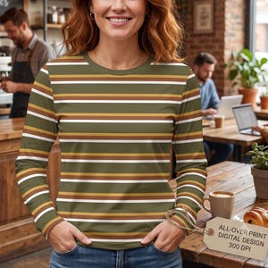 May include: A long-sleeve crew neck shirt featuring a horizontal striped pattern in shades of olive green, brown, white, and mustard yellow. A rectangular tag attached to the sleeve displays the text: ALL-OVER PRINT DIGITAL DESIGN 300 DPI.