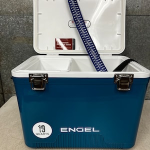 May include: A blue Engel cooler with a white lid and a white sticker that says "19 quarts". The cooler is open and has a blue and white rope handle inside.