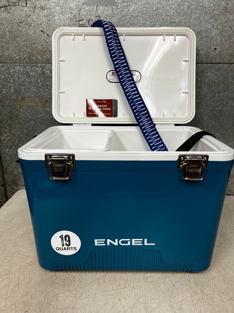 May include: A blue Engel cooler with a white lid and a white sticker that says "19 quarts". The cooler is open and has a blue and white rope handle inside.