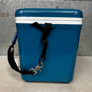May include: A blue cooler with a white lid and a black strap. The cooler has a silver hook on the strap.