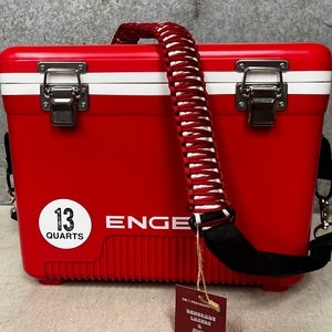 May include: Red 13 quart cooler with a white stripe and a black and white braided strap. The cooler has a white label that says "13 Quarts" and "ENGE" in black lettering.