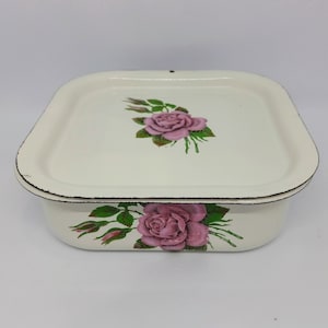 Pode incluir: Prato de forno de esmalte branco com um design floral com rosas cor-de-rosa e folhas verdes.