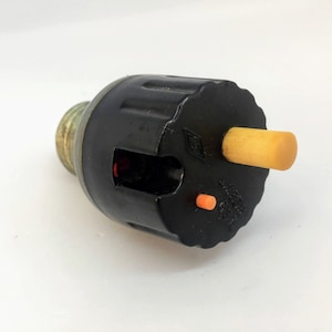 Può includere: Portalampada nero e argento con un interruttore in plastica giallo e arancione. Il portalampada ha una base filettata e un piccolo foro sul lato.