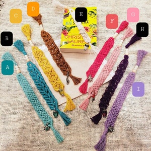 May include: Ten colorful crocheted bookmarks with tassels and charms. The bookmarks are in shades of teal, yellow, brown, pink, purple, and lavender. The charms include a small owl, a star, a heart, and a flower.