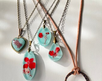 Robin egg blue resin pendant necklace with dried red flowers.