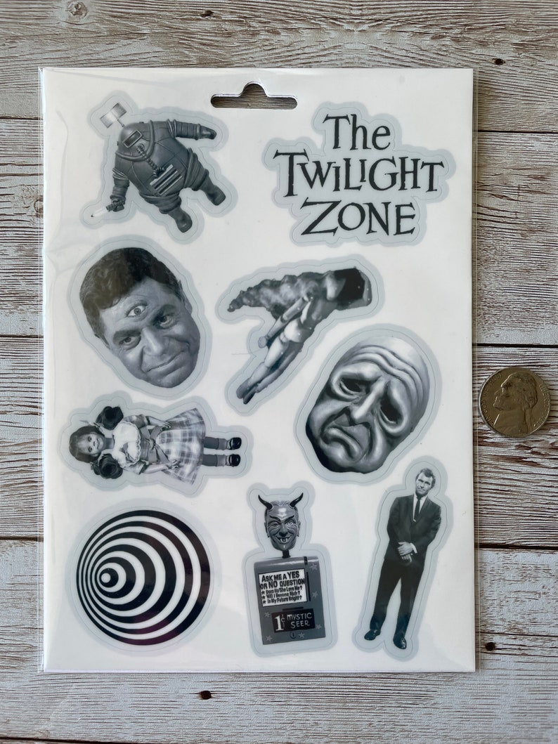 May include: A set of nine black and white stickers featuring characters and imagery from the Twilight Zone television series. The stickers include a robot, a man with three eyes, a hand, a crying face, a girl in a dress, a spiral, a devil, a man in a suit, and a sign that reads "Ask me a Yes or No Question".