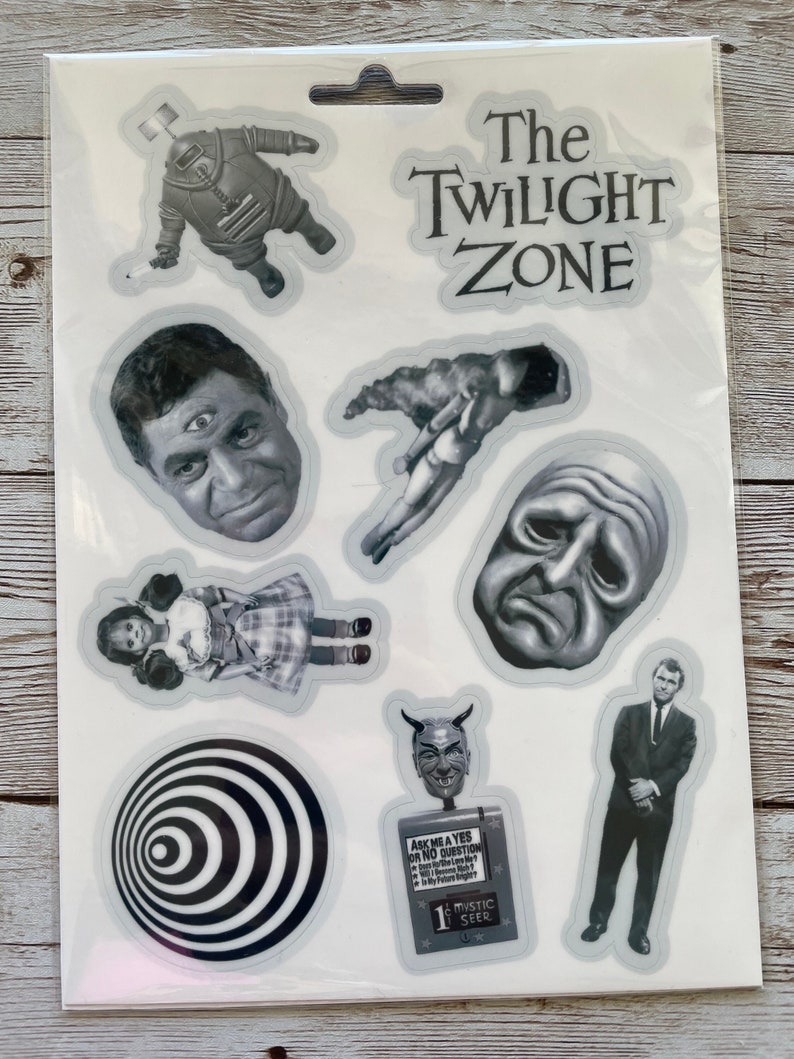 May include: A sheet of clear stickers featuring characters and imagery from the classic television series "The Twilight Zone". The stickers include a man with three eyes, a doll, a man in a suit, a devil head, a face with a frown, a swirling black and white circle, and a man floating in space.