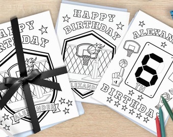 以下が含まれることがあります： バスケットボールをテーマにした白黒の塗り絵3枚。最初のページには「ハッピーバースデー」とバスケットボールのフープとボールが書かれています。2枚目のページには「アレクサンダーの8歳の誕生日」とバスケットボールのフープ、ボール、スコアボードが書かれています。3枚目のページには「ハッピーバースデー」とバスケットボールのフープとボールが書かれています。