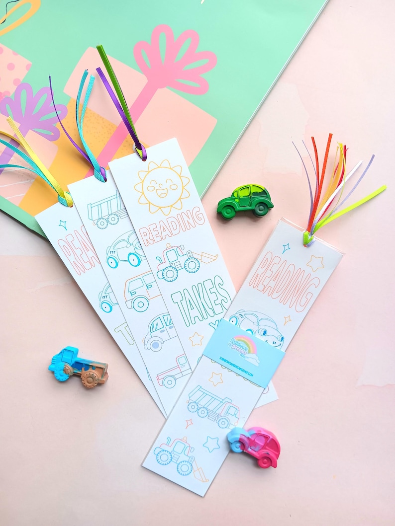 May include: Three colorful bookmarks with a vehicle theme. Each bookmark features a different design with a sun, a truck, and a car. The bookmarks have a white background with colorful outlines and the text "Reading Takes You..." on the bottom.