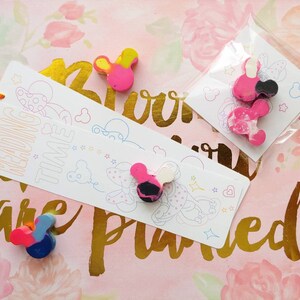 May include: A set of three colorful mouse-shaped crayons with a pink, yellow, and blue color scheme. The crayons are packaged on a white card with the text "Reading Time" and a cartoon mouse illustration.
