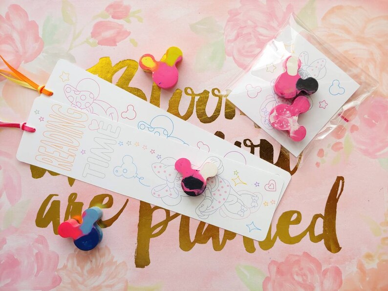 May include: A set of three colorful mouse-shaped crayons with a pink, yellow, and blue color scheme. The crayons are packaged on a white card with the text "Reading Time" and a cartoon mouse illustration.