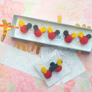 May include: A set of six colorful Mickey Mouse head shaped bookmarks. The bookmarks are red, yellow, and black with a white background. The bookmarks are packaged in a clear plastic bag with a white card that says "Reading Time".