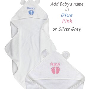 May include: White hooded baby towel with bear ears. The towel features embroidered baby footprints and a name in blue or pink. Text on the image reads: Add Baby's name in Blue, Pink, or Silver Grey.