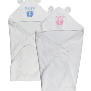 May include: Two white hooded baby towels. One towel has the name "Harry" in blue with blue footprints, and the other has the name "Amy" in pink with pink footprints. Each towel has small bear ears on the hood.