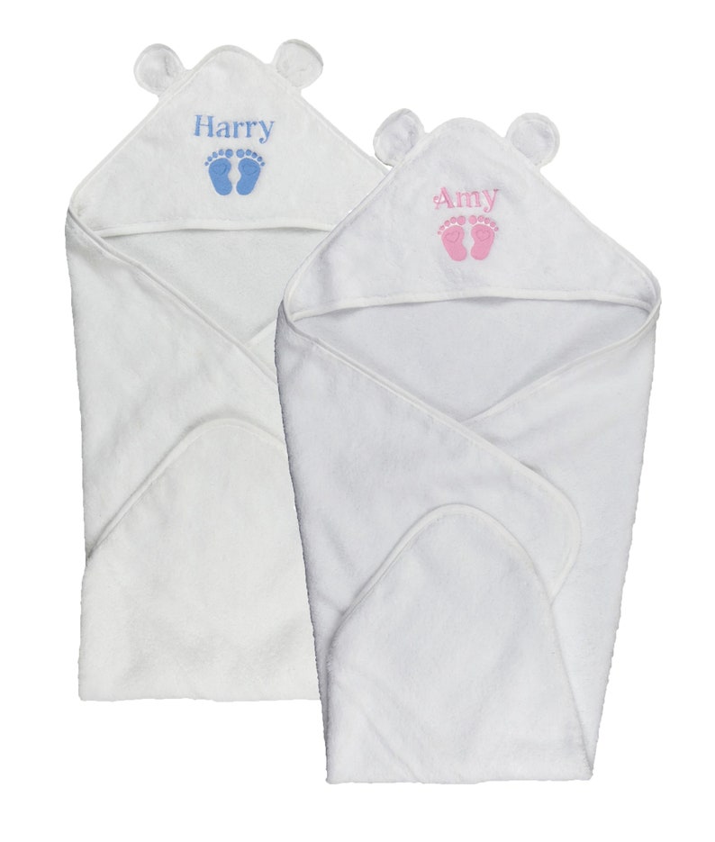 May include: Two white hooded baby towels. One towel has the name "Harry" in blue with blue footprints, and the other has the name "Amy" in pink with pink footprints. Each towel has small bear ears on the hood.
