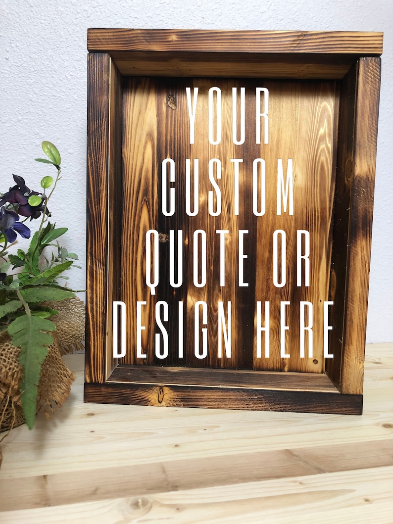 May include: A rustic, wooden shadow box with a dark, charred finish. The box features the text "YOUR CUSTOM QUOTE OR DESIGN HERE" in white, centered within the frame. The wood grain is visible, adding to the handcrafted aesthetic.