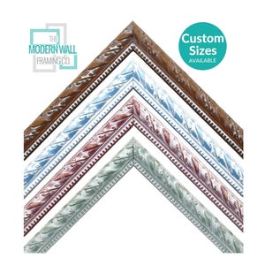 May include: Four nested V-shaped picture frame samples in brown, blue, maroon, and light green. Each frame features an ornate, embossed leaf pattern and a beaded inner edge. The text reads The Modern Wall Framing Co. and Custom Sizes Available.