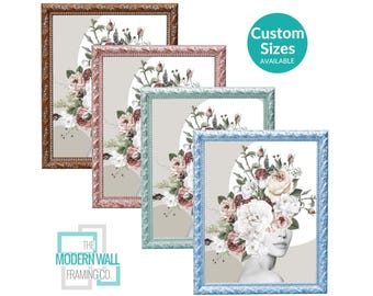 May include: Four rectangular wall frames in bronze, pink, light green, and blue, each containing a print of a person with a large floral arrangement covering their head. The text "Custom Sizes AVAILABLE" and "THE MODERN WALL FRAMING CO." appear.