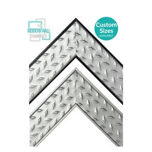 May include: Two corner sections of a picture frame featuring a silver diamond plate metal texture. The top frame has a black inner edge. The logo for The Modern Wall Framing Co. is visible, along with a teal circle stating Custom Sizes AVAILABLE.
