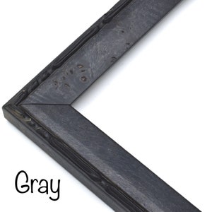 May include: A close-up of a gray picture frame with a textured, wood-like finish. The frame is made of a sturdy material and has a simple, elegant design.