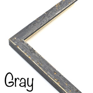 May include: Close-up of a gray picture frame with a distressed wood finish and a gold-colored inner edge. The frame is angled to show the corner.