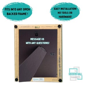 Op de afbeelding: Achterkant van een houten fotolijst met een bruine achterkant en een bericht met de tekst "Neem contact met ons op als je vragen hebt!" De lijst is gelabeld met "The Modern Wall Framing Co."