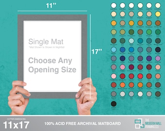 May include: A gray mat board with a 11x17 inch outer dimension. The mat board is acid free and archival. The text "Single Mat" is printed on the mat board. The text "Mat Shown Is Shown In Nightfall" is printed below the text "Single Mat". The text "Choose Any Opening Size" is printed below the text "Mat Shown Is Shown In Nightfall". The text "100% ACID FREE ARCHIVAL MATBOARD" is printed below the mat board. The text "THE MODERN WALL FRAMING CO." is printed below the text "100% ACID FREE ARCHIVAL MATBOARD".