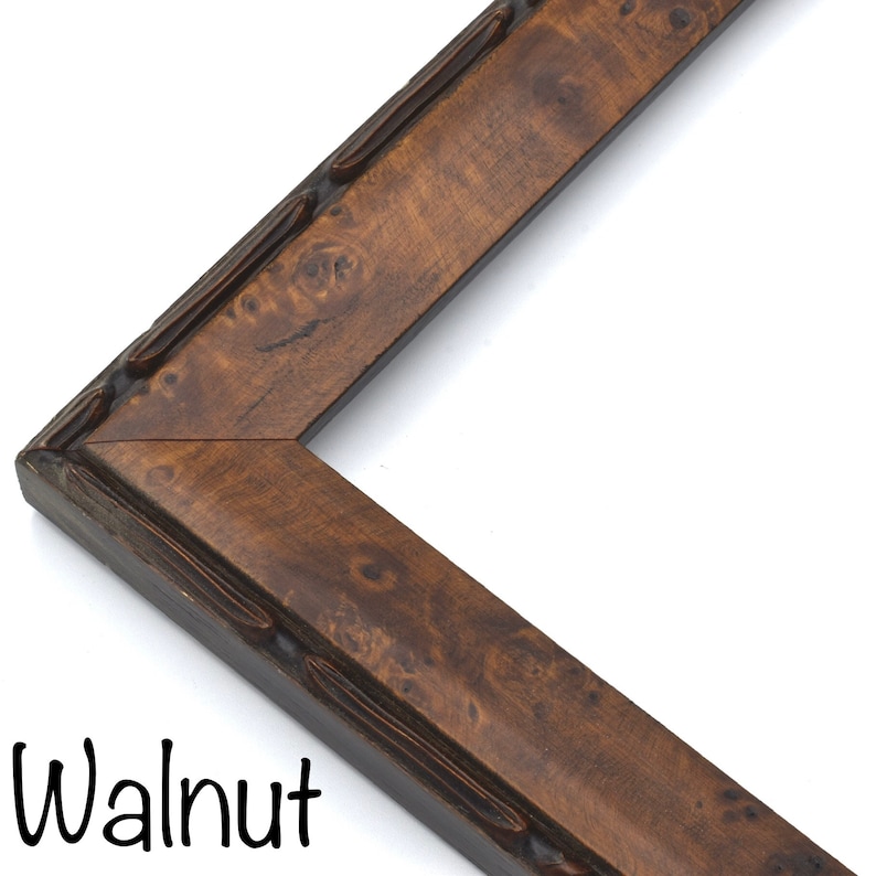 May include: Close-up of a walnut wood picture frame with a decorative edge. The frame has a rich brown color and a natural wood grain.