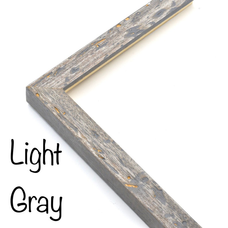 May include: Close-up of a corner of a light gray wood picture frame with a distressed finish. The frame has a thin, light brown inner edge.