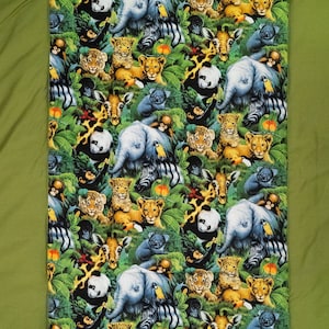 May include: A green fabric with a repeating pattern of jungle animals, including elephants, zebras, giraffes, monkeys, and pandas. The animals are all in a cartoon style and are surrounded by green leaves.
