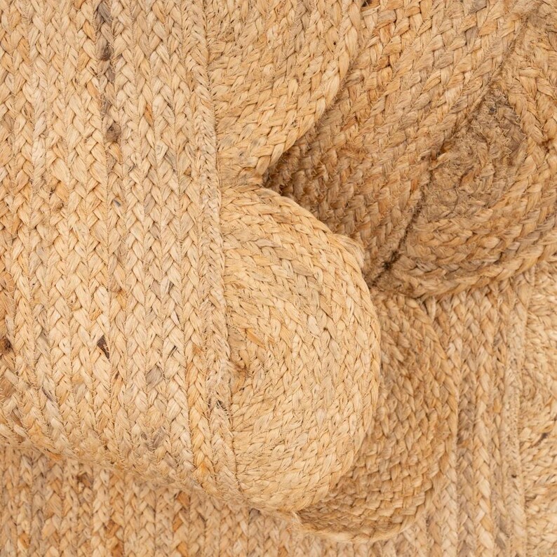 K&ouml;nnte beinhalten: Nahaufnahme eines nat&uuml;rlichen gewebten Teppichs aus Jutefasern. Der Teppich hat eine strukturierte, raue Oberfl&auml;che und eine hellbraune Farbe.