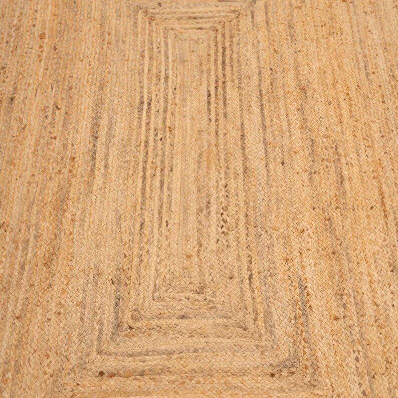 K&ouml;nnte beinhalten: Ein Naturfaser-Teppich mit einem gewebten Muster. Der Teppich ist aus Jute und hat eine hellbraune Farbe.