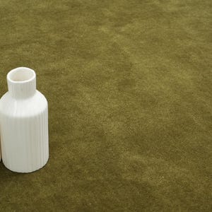 Peut inclure: Deux vases en c&eacute;ramique blanche avec des d&eacute;tails c&ocirc;tel&eacute;s verticaux. L'un est cylindrique avec une ouverture &eacute;troite, l'autre est en forme de bouteille plus haute avec une ouverture plus large. Sur fond vert olive textur&eacute;.