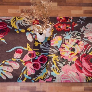 Overhead perspective of a colorful floral hand-tufted runner rug placed on a dark wood floor.