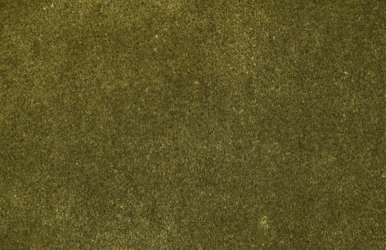 Peut inclure: Gros plan sur un tissu textur&eacute; vert olive. La surface pr&eacute;sente un aspect dense et l&eacute;g&egrave;rement irr&eacute;gulier, avec une l&eacute;g&egrave;re variation de couleur. La texture du tissu sugg&egrave;re un mat&eacute;riau doux, peut-&ecirc;tre tiss&eacute;, adapt&eacute; &agrave; la tapisserie ou &agrave; l'habillement.