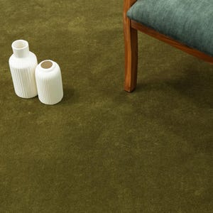 Peut inclure: Deux vases en c&eacute;ramique blanche avec des d&eacute;tails c&ocirc;tel&eacute;s sur un tapis vert. L'un est grand et cylindrique, l'autre est plus court et arrondi. Une chaise en bois avec un coussin bleu-vert est en arri&egrave;re-plan.