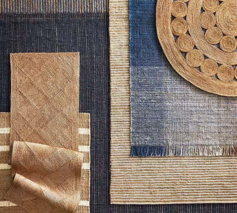 May include: A set of four woven rugs in various shades of brown and blue. The rugs are made of natural fibers and have a textured surface. The rugs are arranged in a grid pattern, with the largest rug in the center.