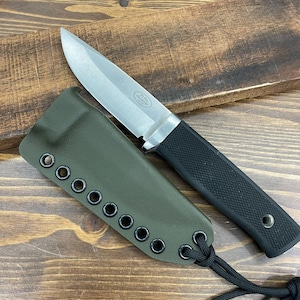 May include: A stainless steel knife with a black textured handle and a green sheath. The knife has a pointed blade and a silver bolster. The sheath is olive green with black eyelets and a black cord.