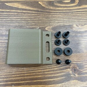 Puede incluir: Una funda de pl&aacute;stico marr&oacute;n claro con ocho ojales de goma negra y dos tapas de pl&aacute;stico negro.