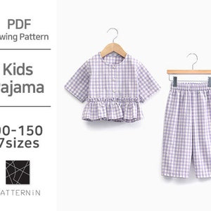 May include: A PDF sewing pattern for kids' pajamas. The image shows a light purple and white gingham pajama set, including a short-sleeved top with a ruffled hem and matching pants. The text on the left side says "Kids Pajama" and "90-150 7 sizes".