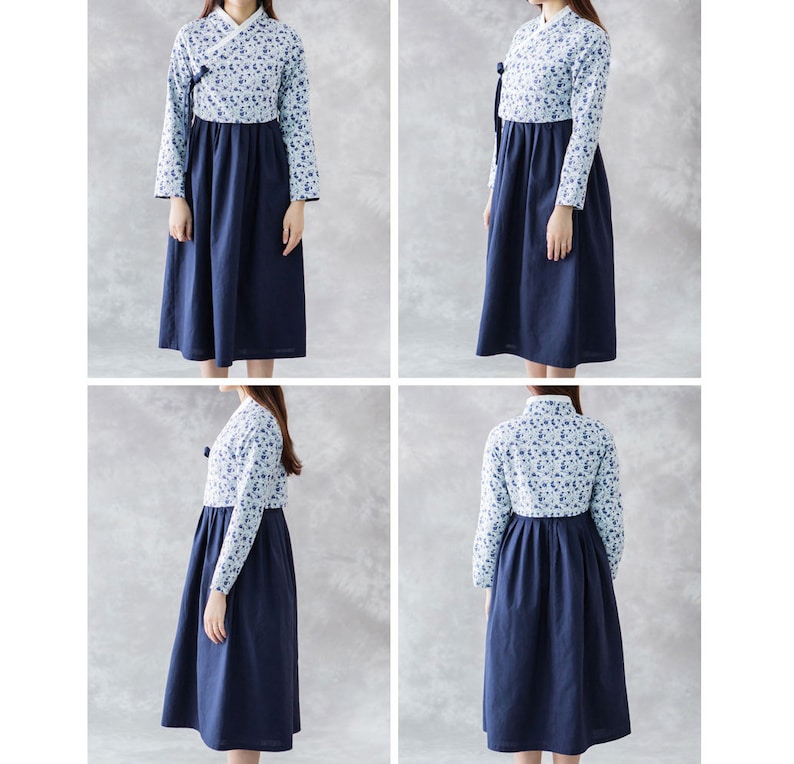 Op de afbeelding: Een jurk met lange mouwen met een bloemenpatroon op de top en een effen marineblauwe rok. De jurk heeft een wikkelhalslijn en een volle rok, wat zorgt voor een bescheiden en elegante uitstraling. De mouwen zijn lang en getailleerd.