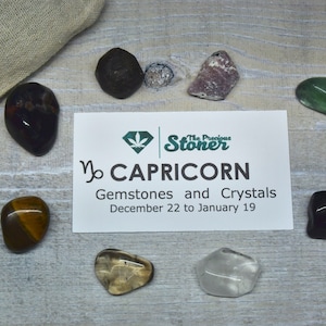 May include: A set of gemstones and crystals for Capricorn, December 22 to January 19. The set includes clear quartz, tiger's eye, smoky quartz, black tourmaline, green aventurine, amethyst, and black obsidian.