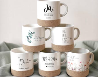 Könnte beinhalten: Sechs weiße Keramikbecher mit Korkböden. Jeder Becher hat ein anderes Design und einen anderen Text. Die Designs umfassen ein Blumenmuster, ein Blattmuster und handschriftlichen Text. Der Text umfasst "Ja", "Lisa & Nico", "Du. Ich. Passt. Franz", "Für Dich", "Mr. & Mrs" und "Anne & Bene".