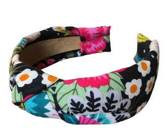 May include: A black headband with a knotted design and a colorful floral print featuring pink, white, green, and blue flowers.
