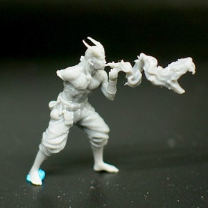Puede incluir: Una figura en miniatura de plástico gris impresa en 3D que representa a un personaje humanoide con cuernos que sopla fuego de su boca. La figura lleva pantalones y un cinturón con bolsas. La figura está en una pose de acción dinámica.