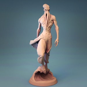 Puede incluir: Escultura de color claro de una figura humanoide con una cabeza única y extremidades alargadas. La figura posa con tela fluida alrededor de la cintura y se alza sobre una base de ola estilizada. La escultura tiene una apariencia detallada y texturizada.